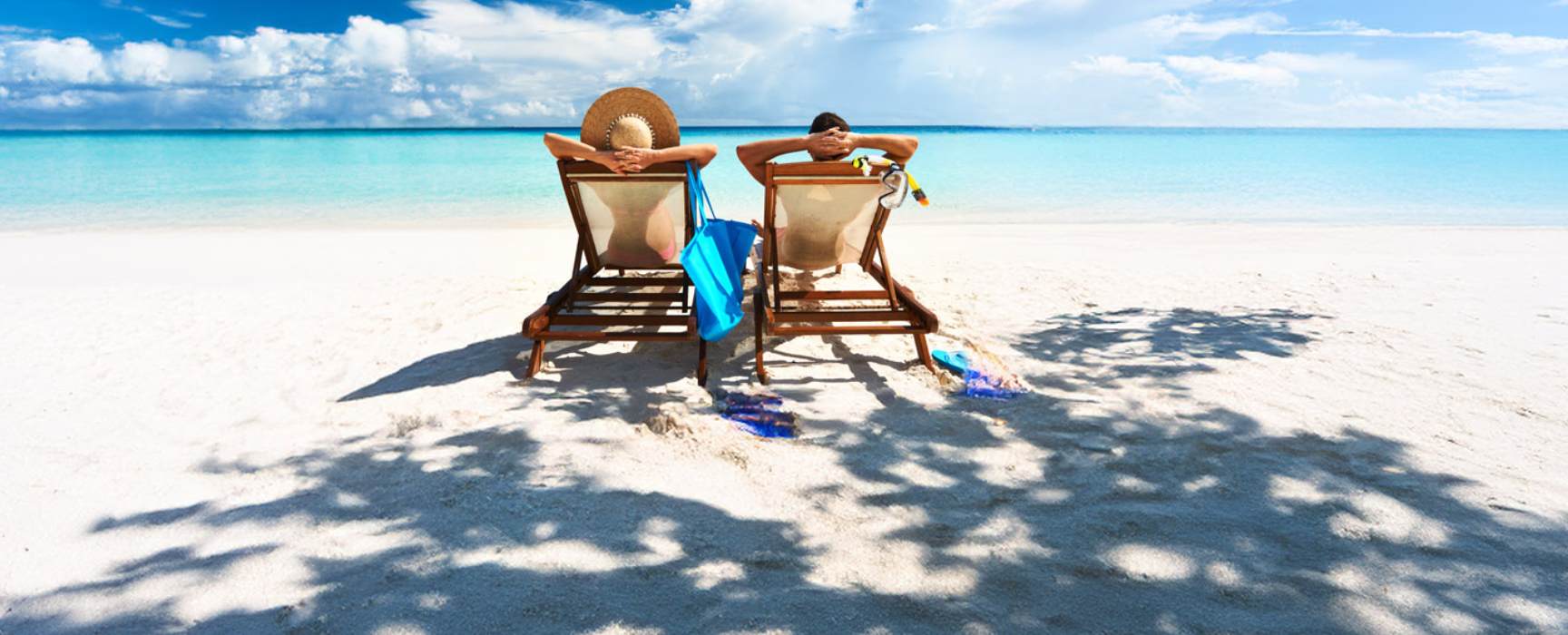 a couple sitting in beach chairs on a beach