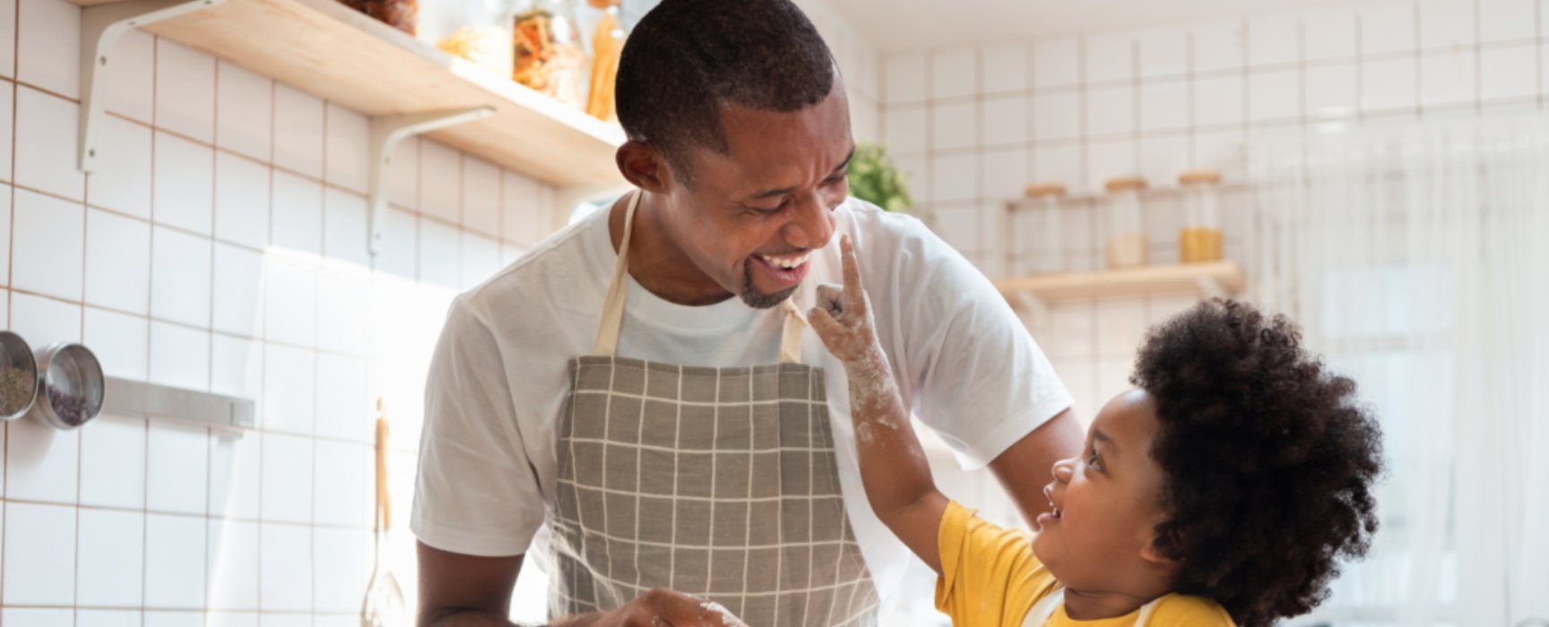 a father and daughter cooking in a kitchen