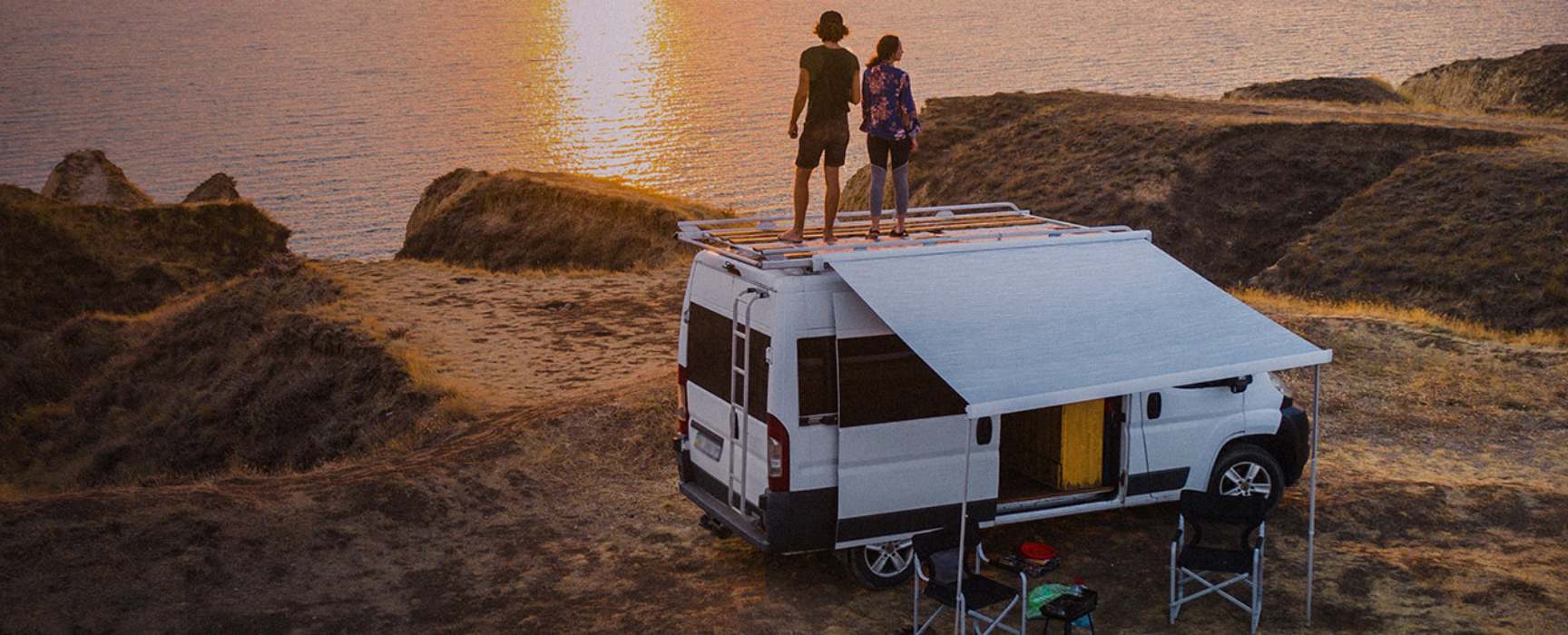 a couple standing on top of their RV