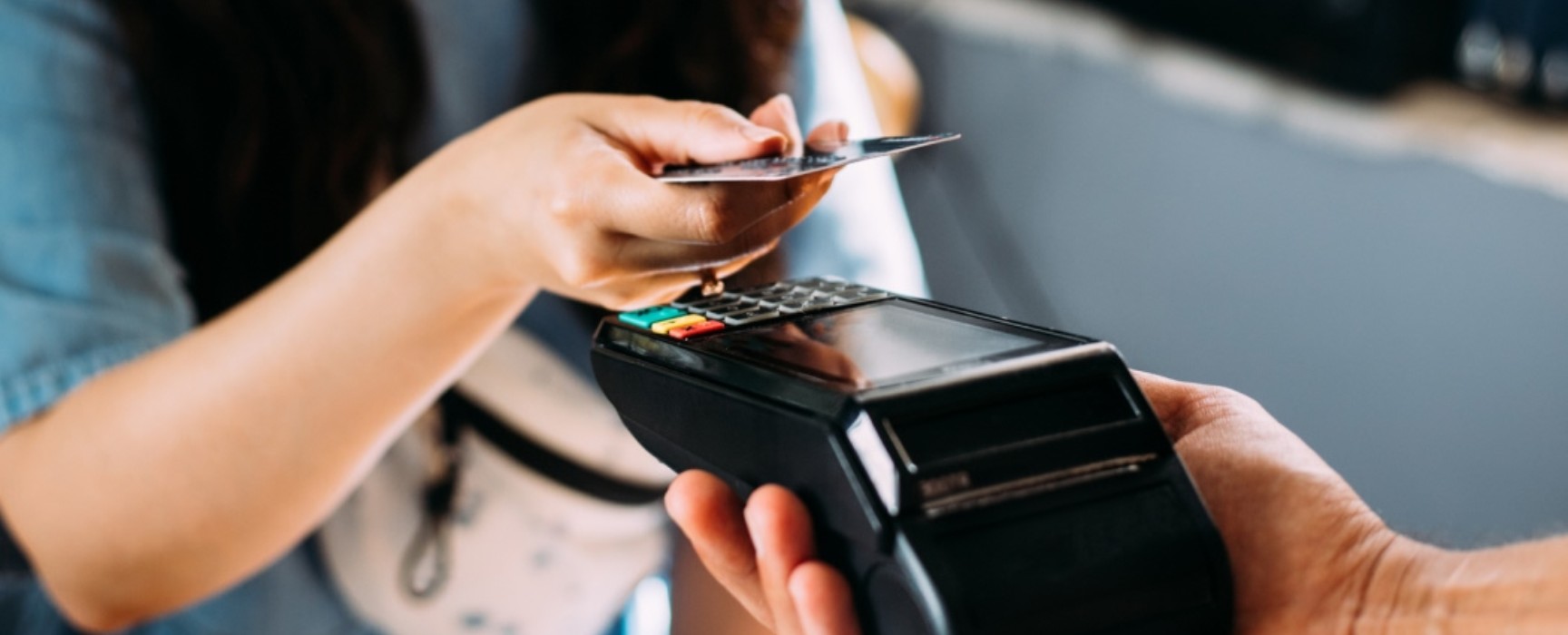 a woman making a purchase using a debit/credit card