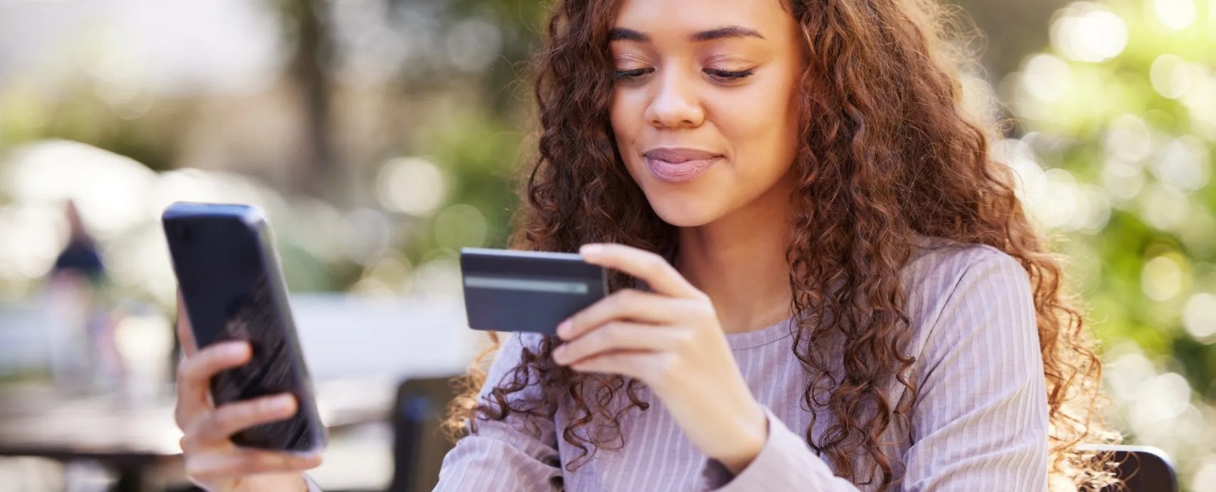 a woman making a mobile purchase using a credit/debit card