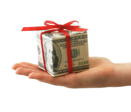 a hand holding a money box with a red bow on top